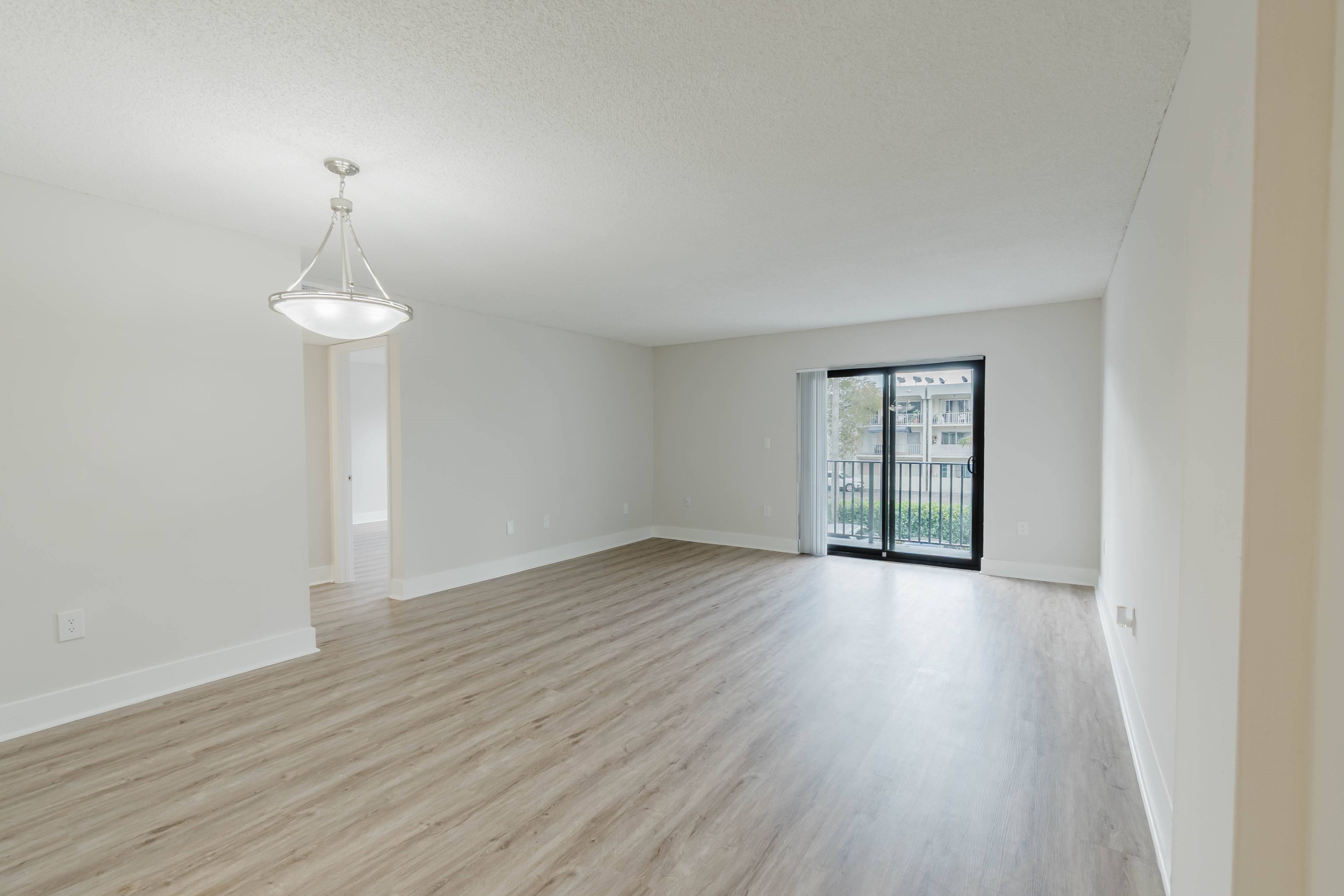 A room with wooden flooring and a chandelier.